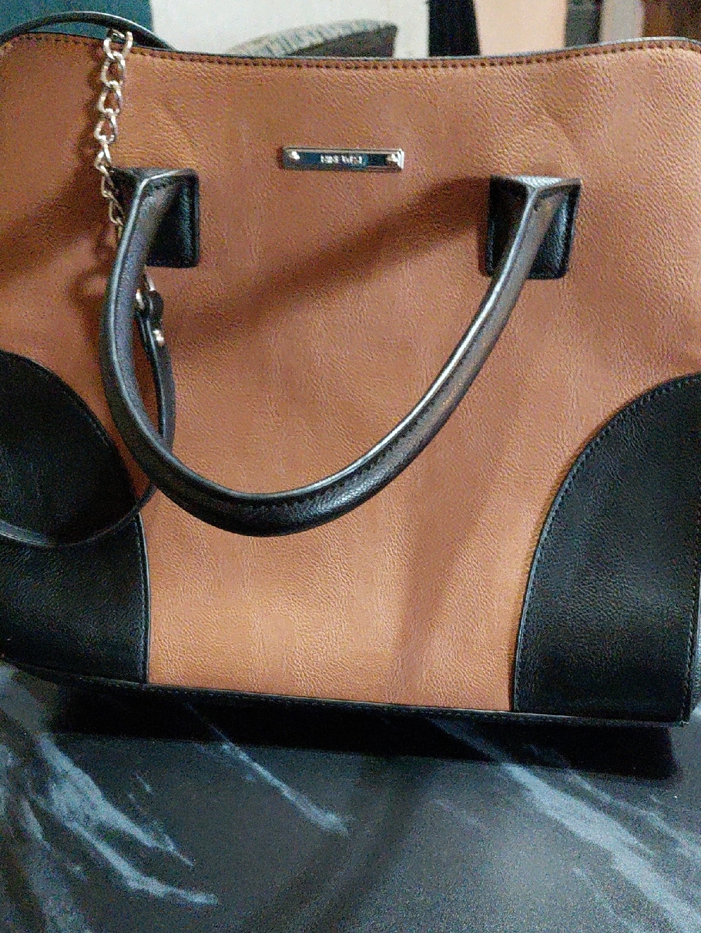 ￼

This item is a Nine West tan and black satchel purse with structured handles.